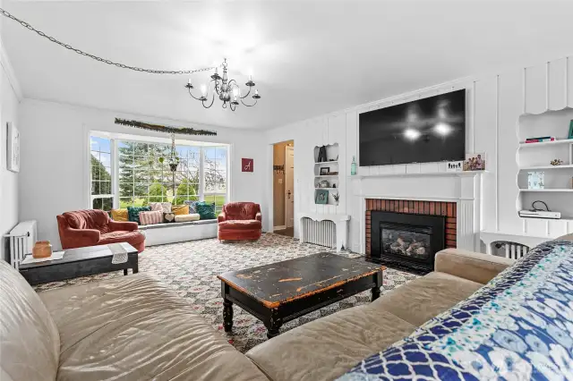 Massive living room with gas fireplace and a second large bay window in the living room.