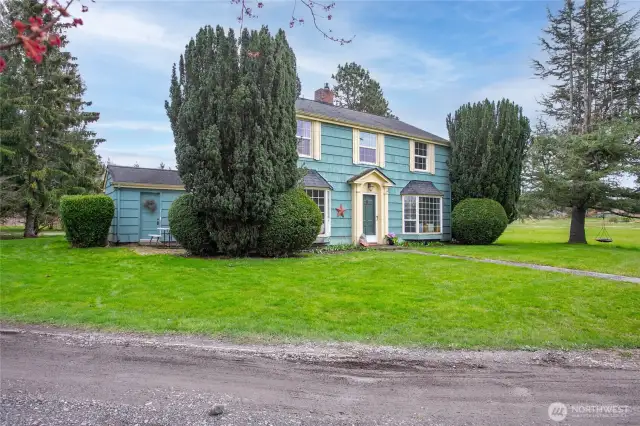 The driveway wraps around this side of the house. Notice the small patio on the left, this is located just off the kitchen and the door you see leads to the mud/utility room.