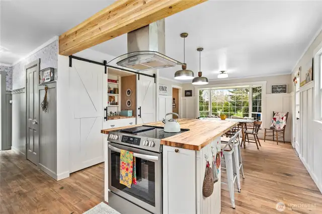 Large island with gorgeous butcher block countertops and a new range, vent hood and updated pendant lights.