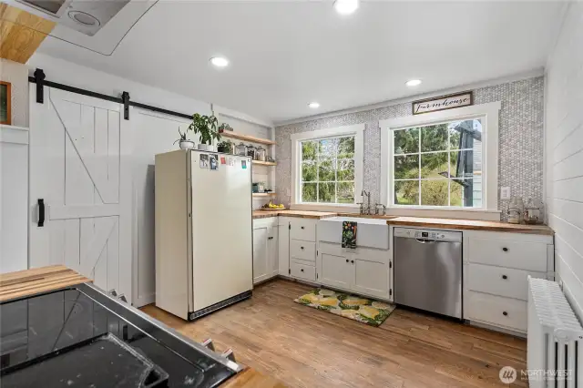 Behind the barn door is a large mud/utility room with ample storage and an exterior door access.