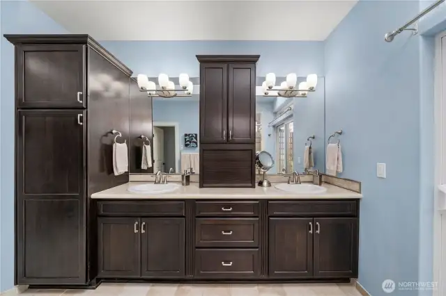 Luxurious primary bath features dual vanity and abundant cabinetry for storage