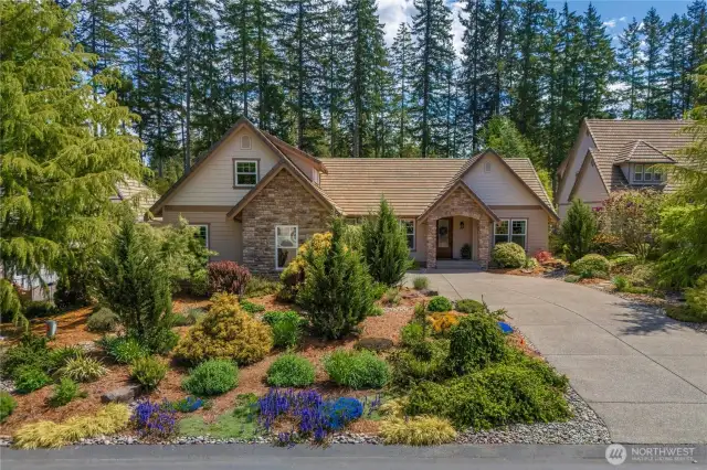 Long private driveway leads  to a large two-car garage, offering plenty of space for guests or extra vehicles
