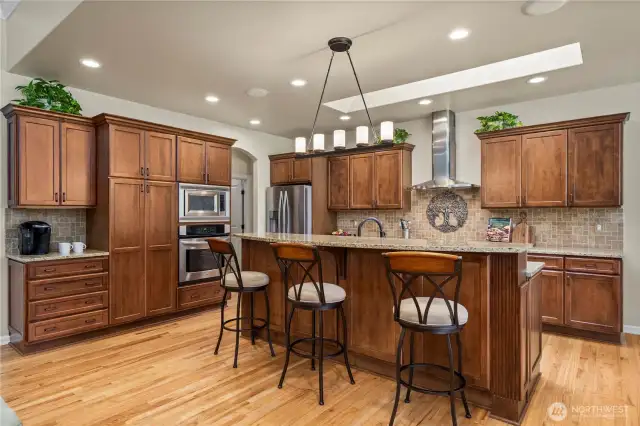 The heart of the home, an inviting kitchen with stunning warm cabinetry and a dining area perfect for hosting dinners or entertaining guests