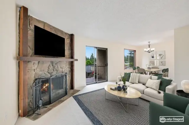 Living Room with wood burning fireplace, view to Dining Area & Slider to Balcony