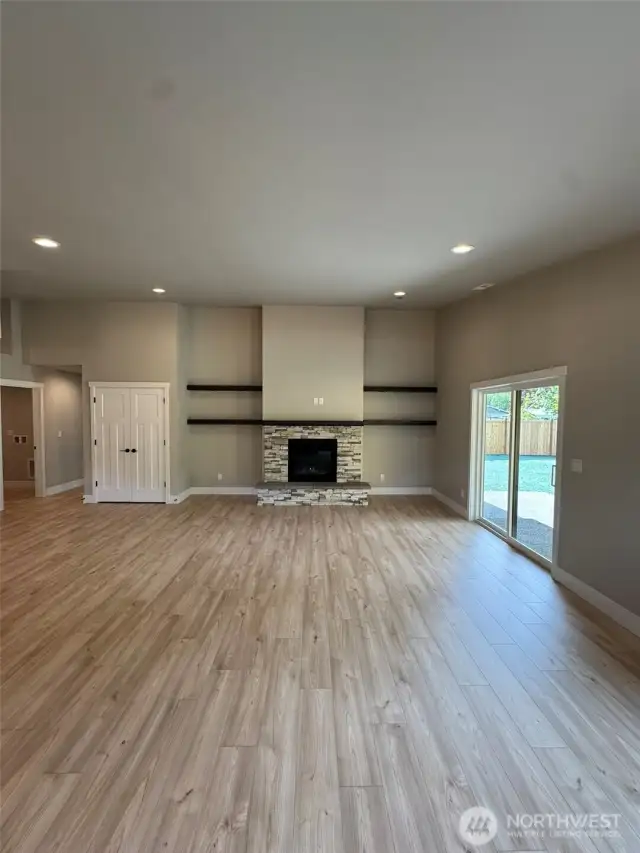 Living room with propane fireplace flanked by wood shelves