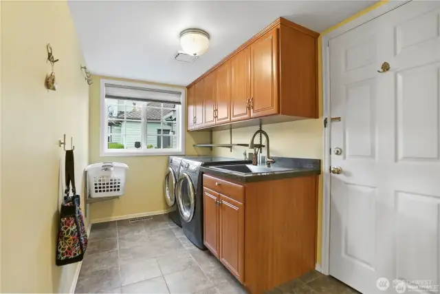 16 / 40Conveniently located off the garage, this thoughtfully designed utility room offers efficient storage and practical workspace. Built-in cabinetry, durable flooring, and a dedicated laundry area maximize convenience, while counter space provides room for sorting and organizing essentials