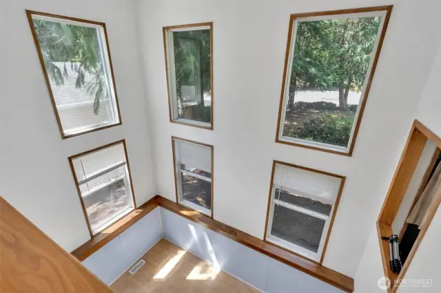 Two story open balcony overlooks the lower level. So many windows pour in the natural light.