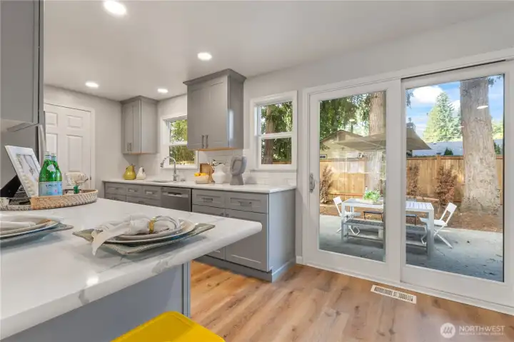 Sliding doors lead to a large, fenced backyard, ideal for entertaining, gardening, or relaxing.