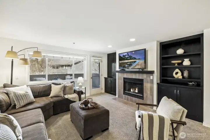 Welcome Home! Relax in your light-filled Living Room with Cozy Fireplace and Custom Cabinetry