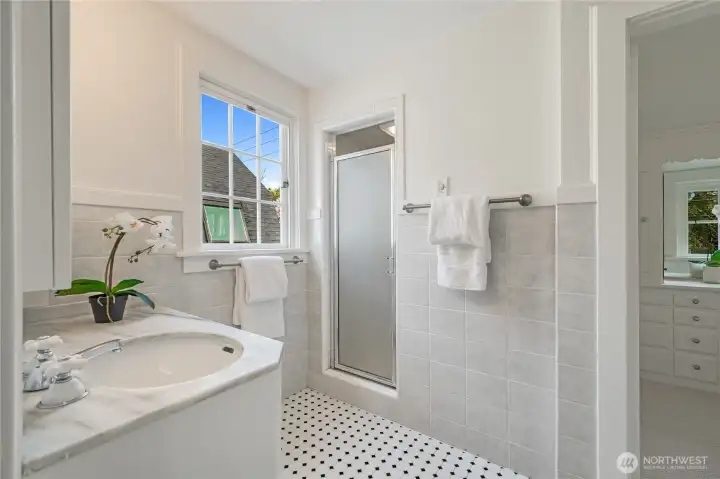 Upstairs timeless bathroom with walk-in shower, immaculately maintained and sparkling clean.