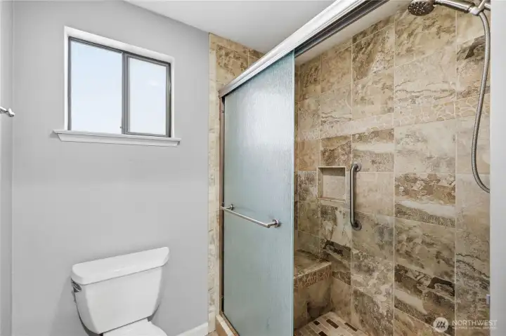 Walk in shower with a nice place to sit and a grab bar. Safety first.
