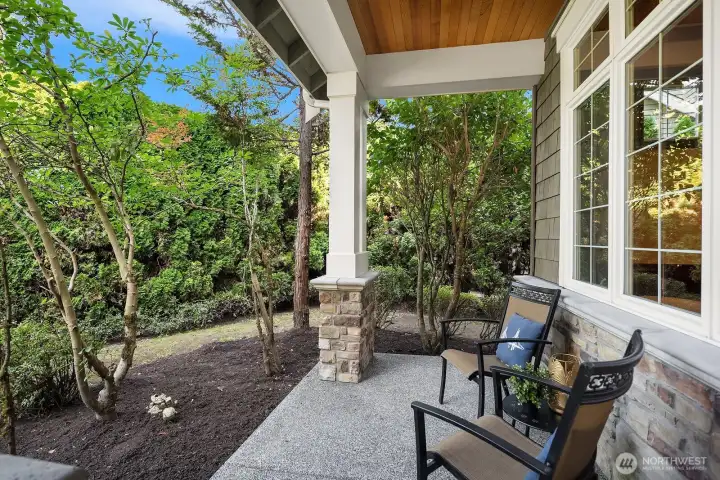A charming covered front porch offers the perfect spot to relax, featuring classic craftsman columns, a cozy seating area, and tranquil views of the surrounding mature landscaping. This inviting outdoor space sets the tone for the thoughtful design found throughout the home.