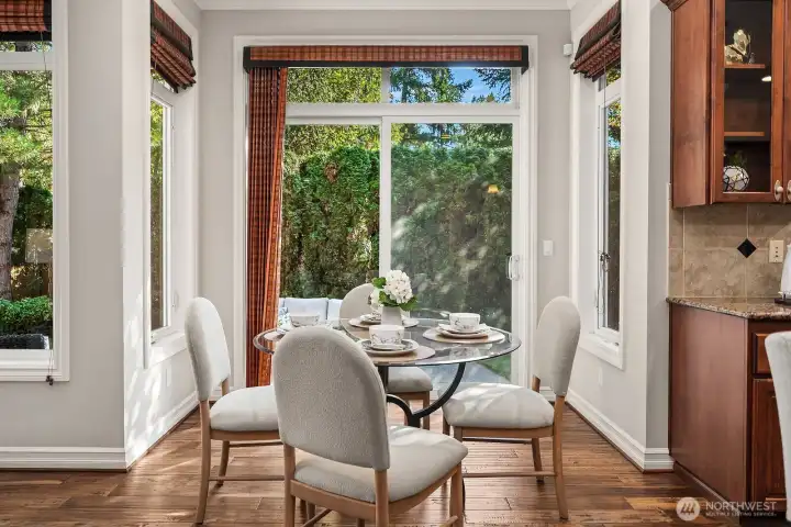 The sun-drenched breakfast nook is a charming and intimate space, framed by large windows that flood the area with natural light and offer peaceful views of the lush backyard. Elegant window treatments and warm hardwood floors make this the perfect spot for casual morning meals or a quiet afternoon retreat.