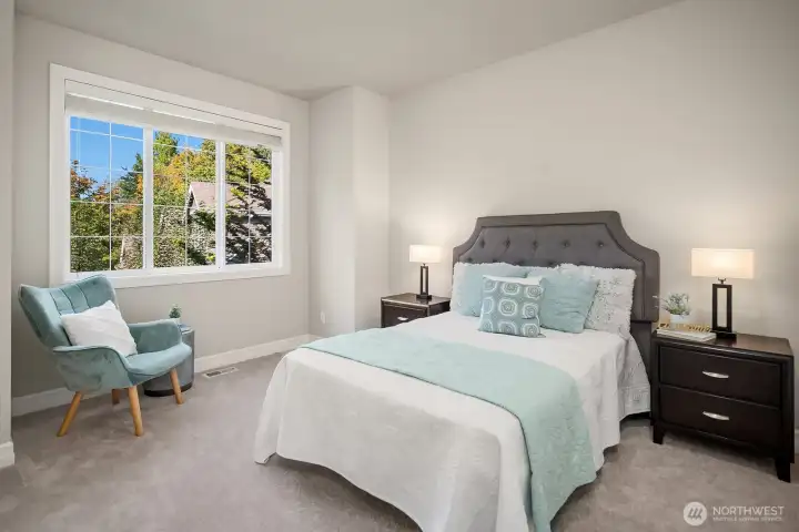 Another generously sized secondary bedroom continues the home's tradition of quality and comfort, with large windows framing beautiful views of the surrounding greenery and filling the space with warm, natural light. Plush carpeting and a soothing neutral palette make this a versatile and inviting room ready to adapt to any need or personal style.