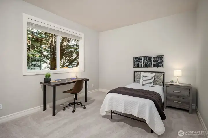 This versatile secondary bedroom showcases its flexibility with ample space for both sleeping and a dedicated study or workspace, making it an ideal option for students or those working from home. Bright natural light, plush carpeting, and a clean neutral palette create a calm and functional environment that suits a variety of living needs.