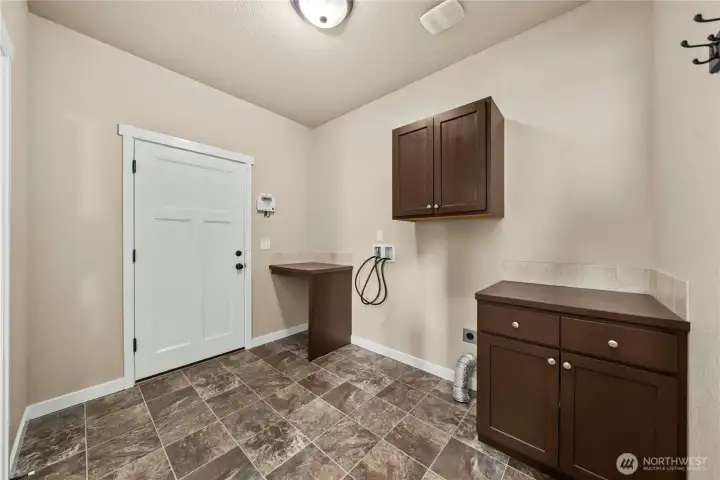 Large main-floor laundry room with upper and lower cabinets