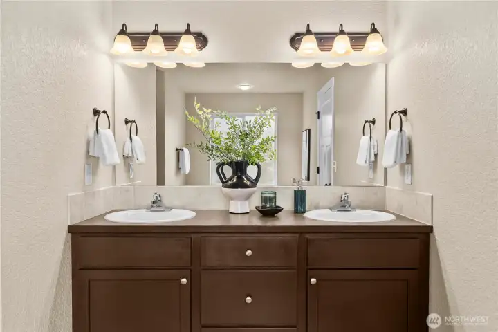 The primary bathroom features a dual-sink vanity...