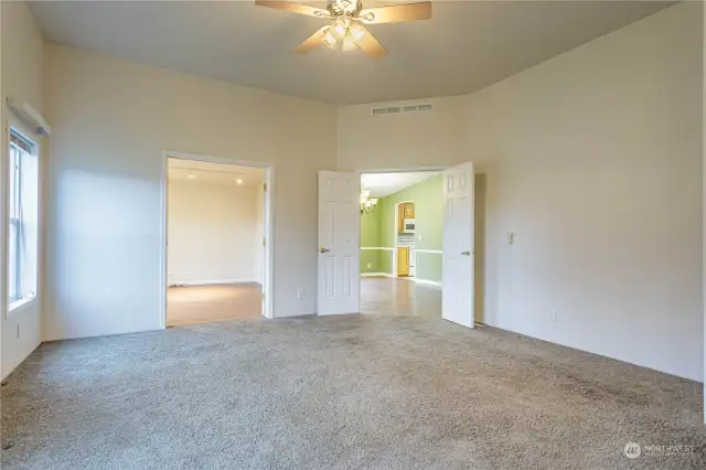 Primary bedroom looking towards attached bonus room/office and dining room