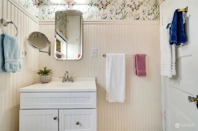 The vanity and mirror complement the vintage charm of this sunny bathroom.