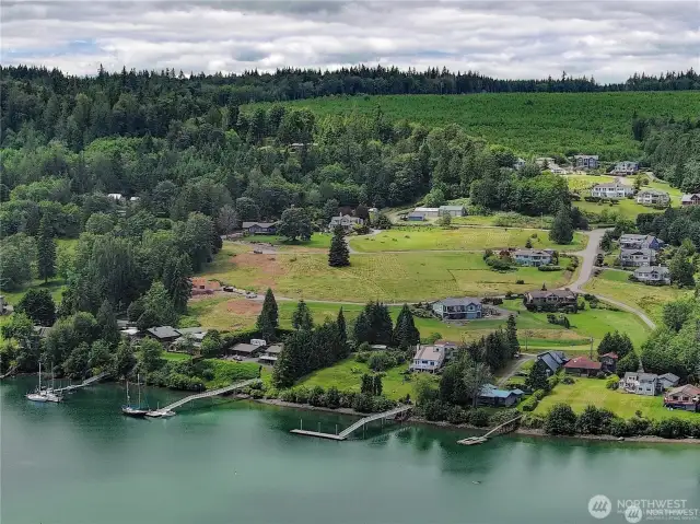 A drone view of Sunrise Cove, which does not include the waterfront homes. Lot 5 is in just to the right at the top of the widest street on the rigt-hand side. There's a large fir tree in te lot.