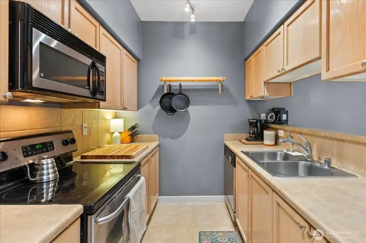 Bright kitchen workspace includes a double-basin stainless steel sink and generous counter space for meal preparation.
