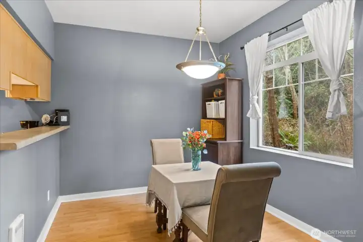 The dining area flows effortlessly into the kitchen, separated by a breakfast bar for additional seating.