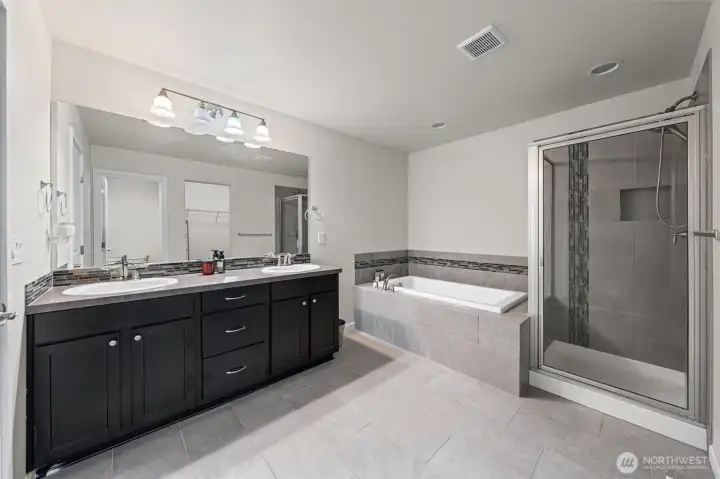 Primary Bath. Double vanity, bathtub, shower and separate toilet area.