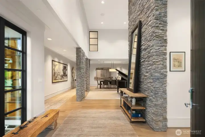 Stone and wood accents anchor the soaring 2-story entry.