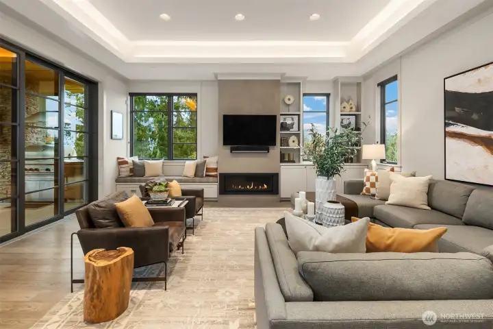 The family room is an invitation to relax with its cozy fireplace flanked by a window seat and custom built-ins.