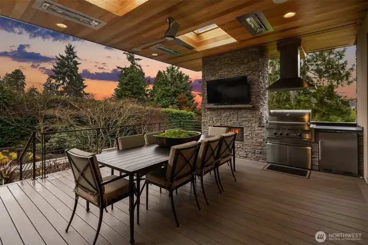 Year-long al fresco enjoyment awaits on the covered patio with Wolf grilling station, fireplace, overhead heaters, and mounted flat screen.
