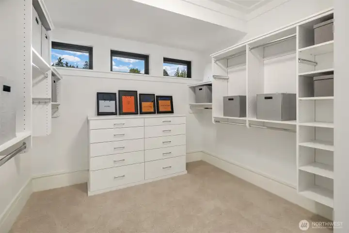 Dreamy walk-in closet infused with natural light from privacy windows.