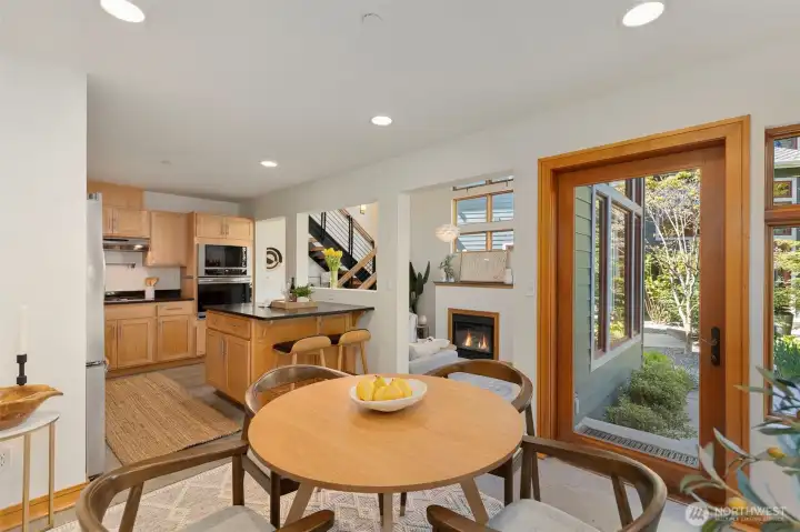 The dining area opens to the private garden patio through a wood-framed glass door — an easy transition to outdoor living.
