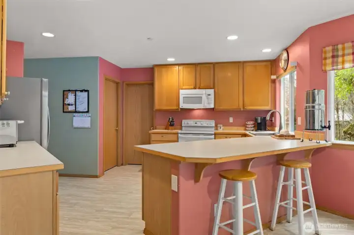 The door just to the left of the oven and microwave opens to a massive pantry that extends the entire way along the back wall. The next door over opens to the laundry room.