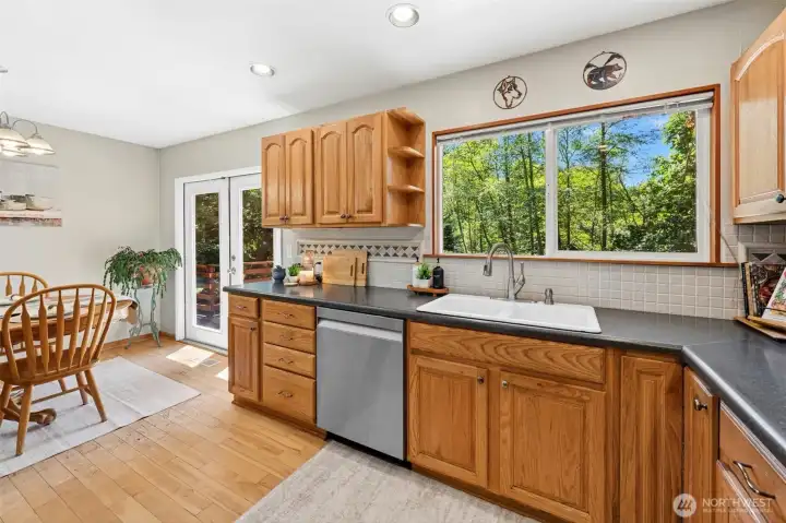Kitchen provides plenty of cabinets for storage, travertine tile backsplash, and formica counters