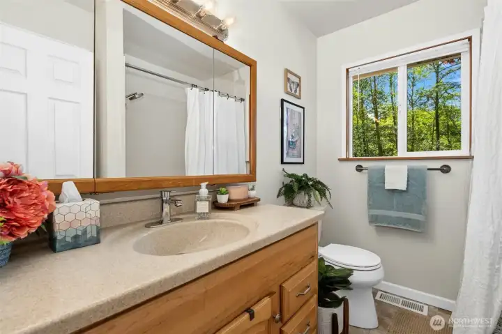 Full main level bathroom, updated vinyl flooring, and shower/tub insert