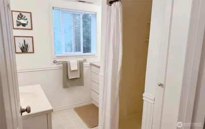 Lower level 3/4 bath with vanity space, extra storage, and linen closet