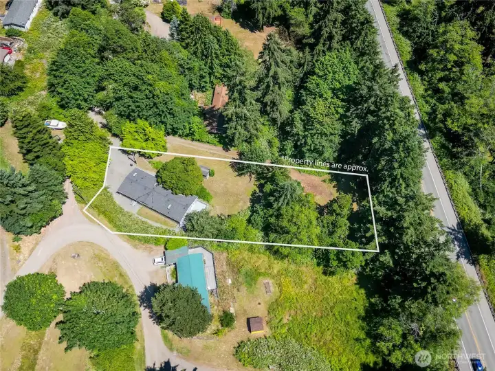 Approximate property lines illustrate the generous lot size, offering a clear perspective on the home's yard, wooded surroundings, and available outdoor space.