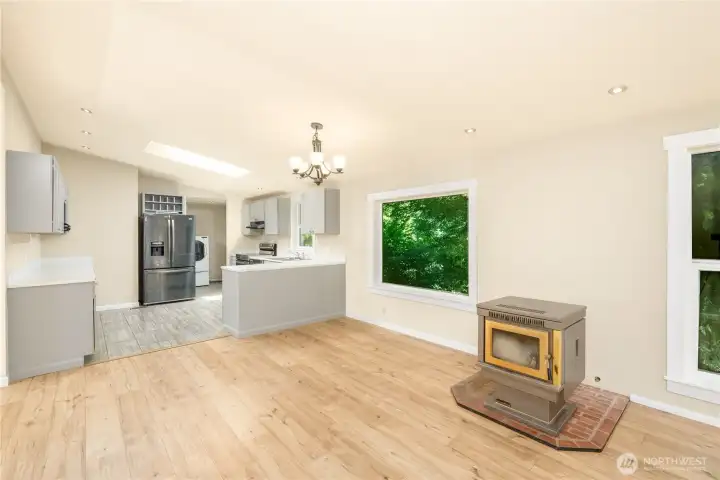 Open-concept living and dining area anchored by a pellet stove (you need to finish the install) and connected to the updated kitchen.