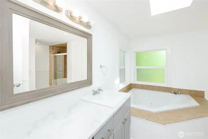 Primary ensuite with a jetted soaking tub, separate shower, and plenty of room to unwind.