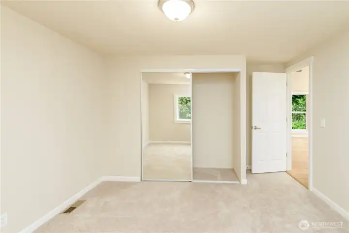 The third bedroom offers soft new carpet, a spacious closet with mirrored doors, and a versatile layout that's perfect for guests, family, or a dedicated home office, all finished in a bright, neutral palette that's ready for your personal touch.