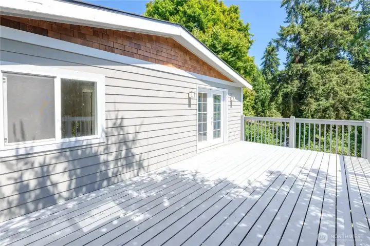 Enjoy outdoor living on the spacious freshly painted deck, where mature evergreens create a peaceful, private setting. With plenty of room for dining, entertaining, or simply unwinding, this inviting outdoor space feels like an extension of the home's open living area.