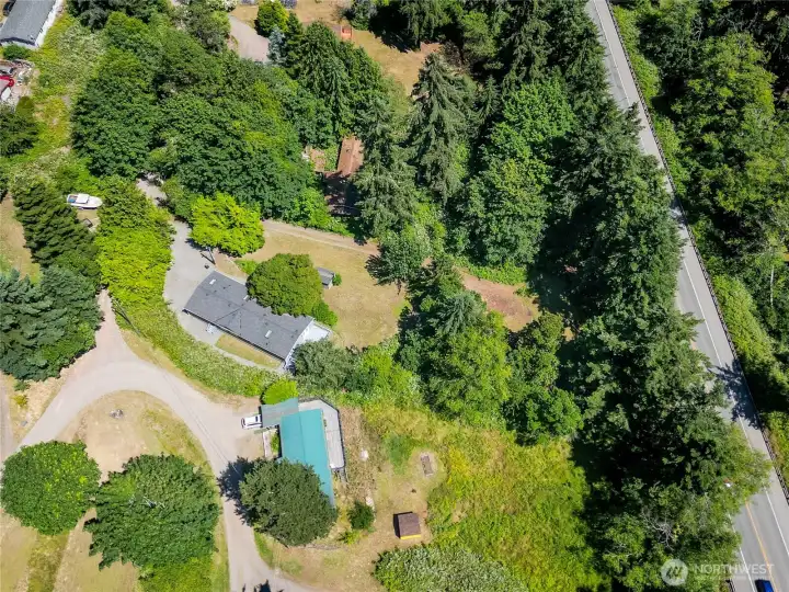 An overhead view showcases the property's generous yard, mature trees, private setting, and proximity to the shoreline—offering a rare blend of space, privacy, and convenience.