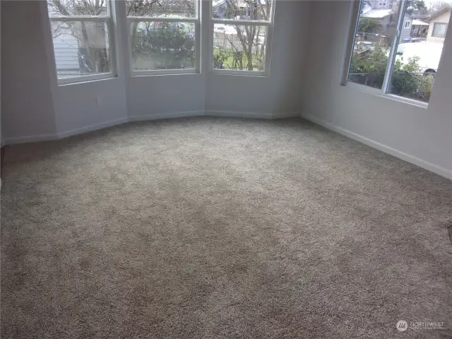 Living room has new carpet, fresh paint, and a bay window.