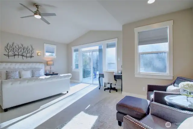 Main floor primary suite with private deck overlooking the back yard and trees.