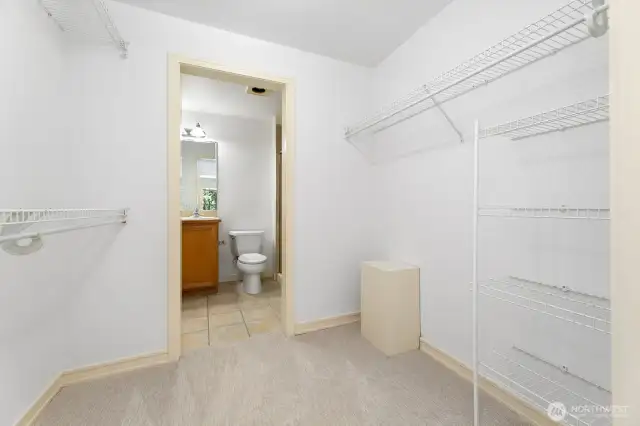 Primary bedroom walk-in closet & three-quarter bath