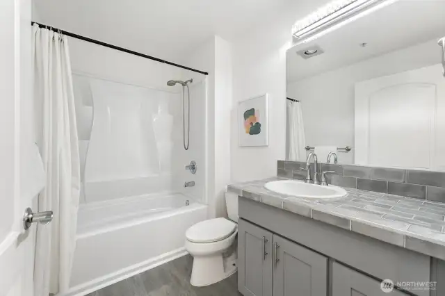 As we exit the primary bedroom and make our way down the hallway, you'll come across the recently updated second bathroom in this unit.