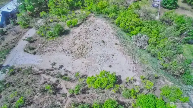 Lower tier aerial view of excavated RV site prepped area with domestic water on 1.84 acre parcel