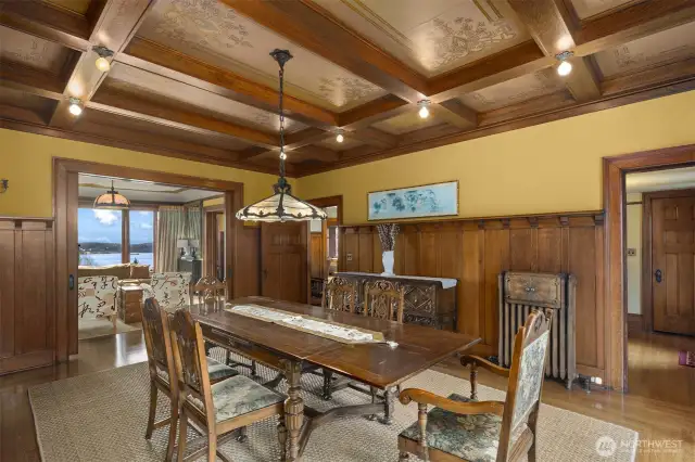 Dining room with leaded glass bay window. original lighting and Tiffany school fixture, pocket doors, box beam ceiling, plate rail paneling and a very rare plate warmer.