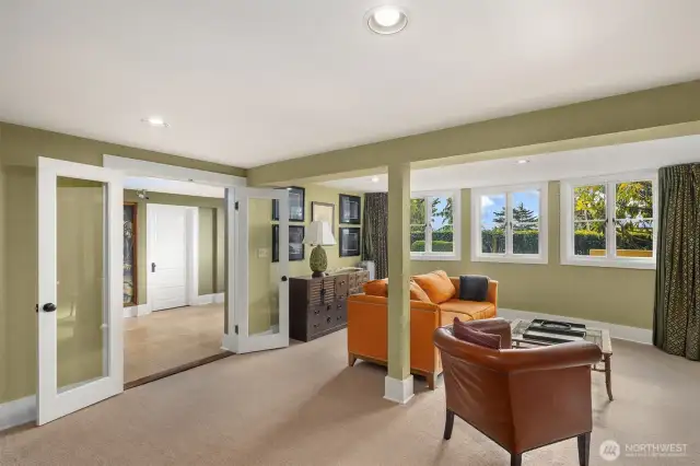 Bay windows from media area look out to yard and views. Large area with space for games, plus dedicated workout room, bedroom, 3/4 bath and full kitchen. Two exterior doors walk out to grassy yard and patios.