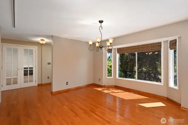 Large living room with space for over sized dining table and bookshelves or displaying art on amply sized walls.